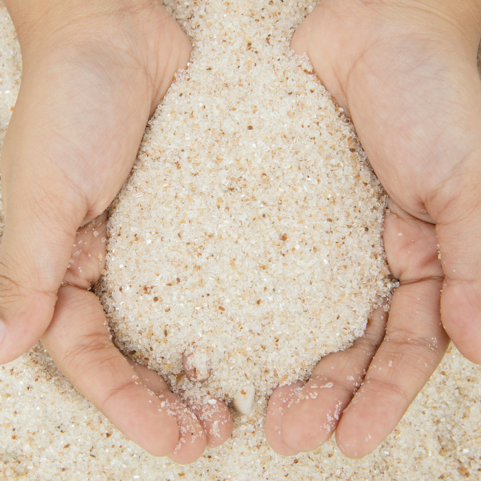 mains qui tiennent du sable